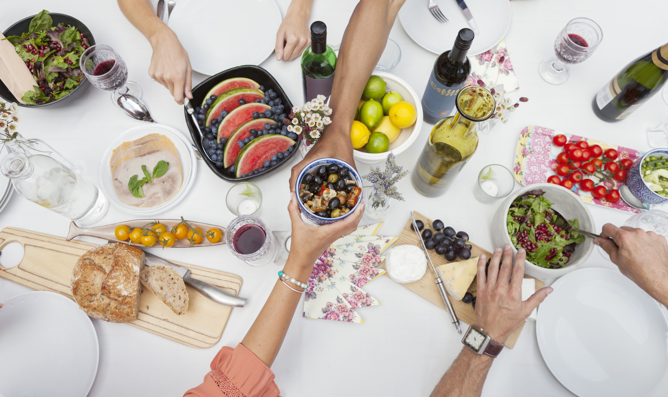 Overhead view of friends enjoying garden party lunch on patio table