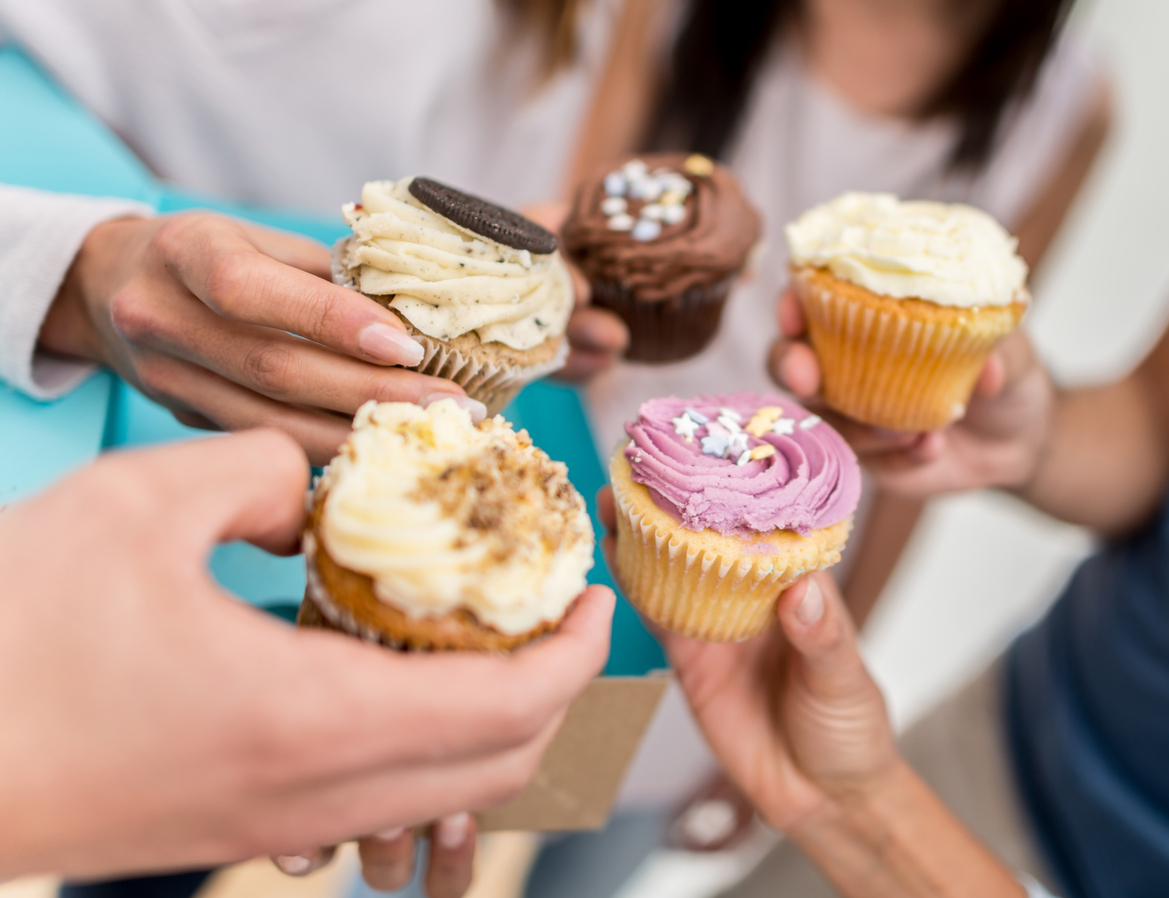 group-of-people-holding-cupcakes-in-a-circle