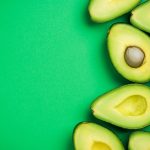 avocado halves on bright green background