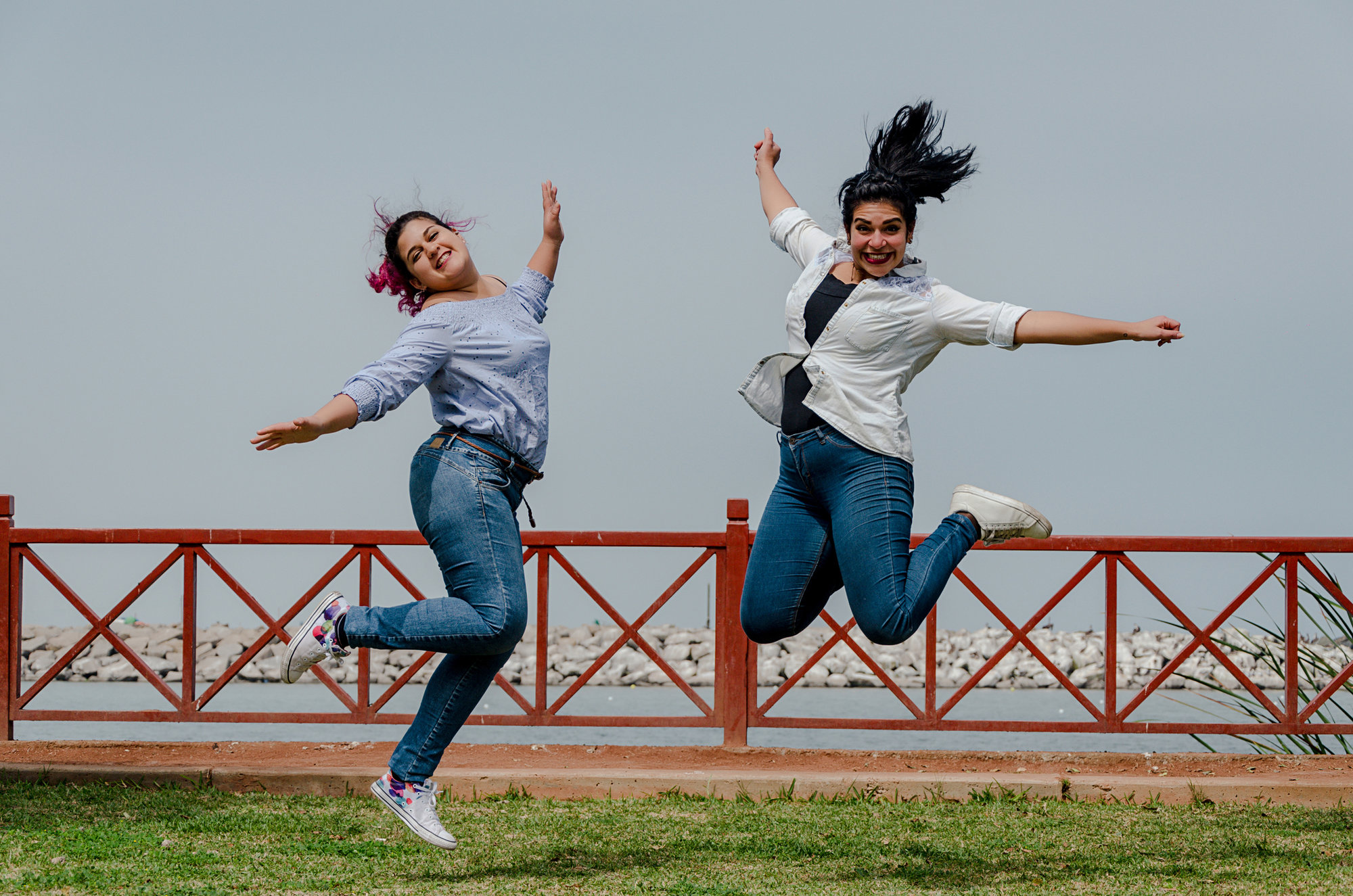 Two happy young women jumping in air
