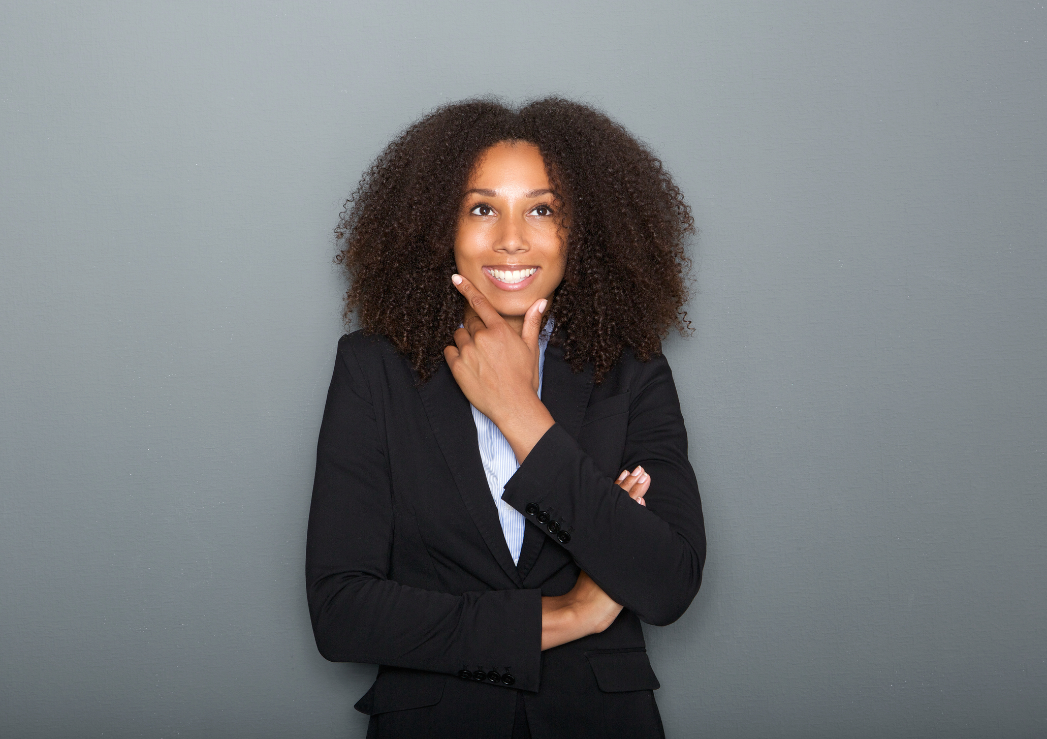 Young black woman looking happy while thinking