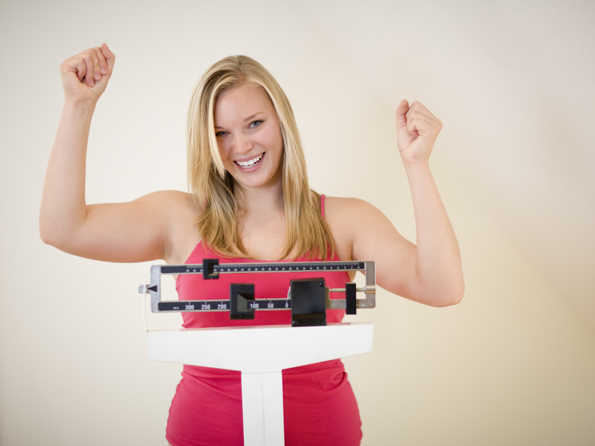 Happy blonde woman on weight scale