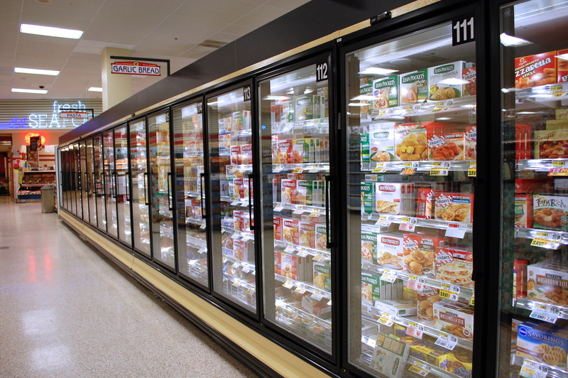 Frozen food cases in a supermarket aisle.
