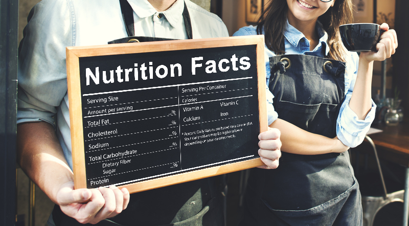 Nutrition facts on a chalkboard with two people standing behind it