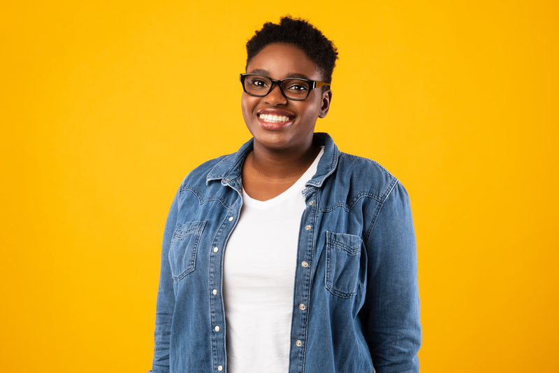 Lady Smiling To Camera Standing Posing In Studio Over Yellow Background, Wearing Eyeglasses